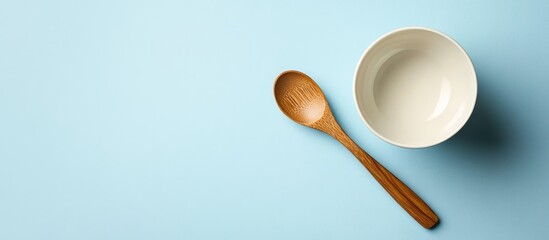 Poster - Empty sauce bowl and wooden spoon on a blue background. with copy space image. Place for adding text or design