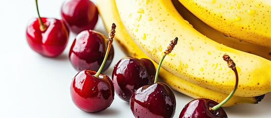 Wall Mural - Close up of bananas and cherries placed together on a white background Isolated tropical fruits with copy space Natural healthy food Fruits for desserts