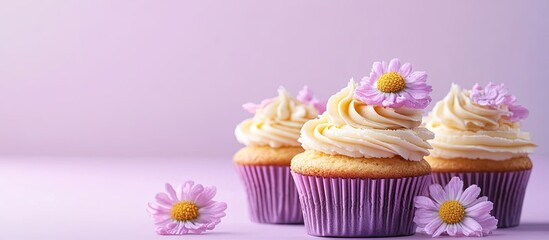Poster - Cupcakes adorned with yellow cream on a violet pastel background with copy space perfect for a birthday or wedding greeting card