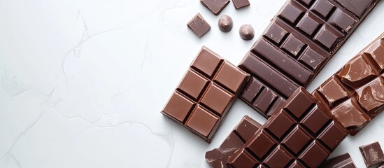 Poster - Variety of delicious chocolate bars on a white tiled table top view Copyspace available