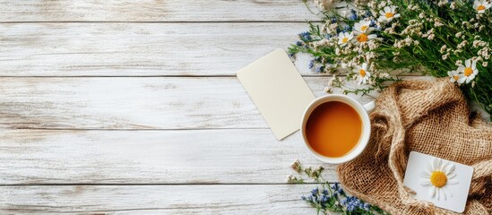 Poster - Garden flowers a gift a coffee cup and an empty postcard on a white rustic wooden table background Vintage card flat lay top view Breakfast for Mother s Day or Women s Day. with copy space image