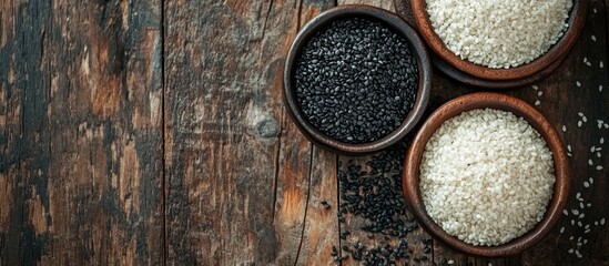 Poster - Black sesame and white sesame seeds on a wooden table. with copy space image. Place for adding text or design