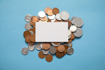 Wall Mural - Stack of coins and empty business card on the blue background. Finance