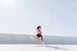 © muse studio - Woman jogging on a sunny day in an urban environment showcasing fitness and outdoor activity