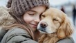 © Julia Jones - National Random Acts of Kindness Day Warm hug between caucasian young girl and golden puppy on a winter day