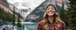 © Viacheslav - Happy woman in plaid shirt and beanie smiling against majestic mountain backdrop in nature travel adventure portrait