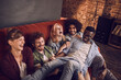 © Marko Geber - Group of friends laughing and having fun on a couch in bar