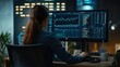 © Natpasit - Late Night Analyst: A woman intently focuses on data graphs on her computer screen, her silhouette illuminated against a dark backdrop.
