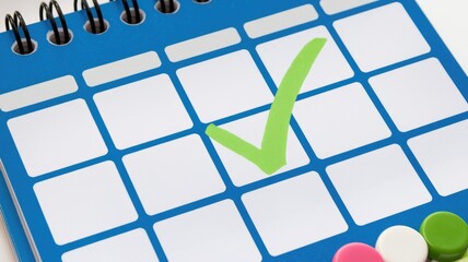 Leinwandbilder - A blue desk calendar with a green checkmark indicating a scheduled event or completed task.