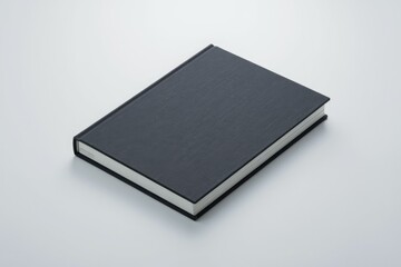 Leinwandbilder - A closed dark-gray hardcover book rests on a white surface.