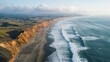 © Rinowz - Aerial photograph of a rugged coastline with crashing waves and sandy shores, illustrating the dynamic interaction between land and sea.