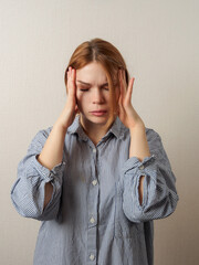 Canvas Print - A woman experiencing a migraine headache closes her eyes and holds her head, expressing discomfort fatigue.