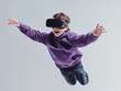 © Artificial South - Virtual Reality Flight: A young boy wearing a VR headset, eyes wide with excitement, leaps into the air with outstretched arms, his virtual reality experience taking him on a thrilling journey.
