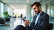 © Ektala - Annoyed clerk Businessman checking smartphone in modern office lobby