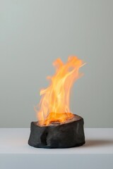Wall Mural - A small fire is burning in a rock. The fire is orange and the rock is black. Concept of warmth and comfort, as well as a feeling of being close to nature