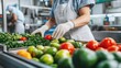 © thenort - Worker inspecting fresh produce on a conveyor belt in a food processing plant.