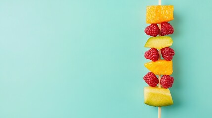 Wall Mural -   Fruit skewer with raspberries, pineapple, and pineapple slices against blue background