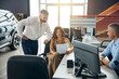 © Viacheslav Yakobchuk - Happy couple studying documents of new car near salesman manager at car salon