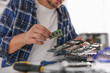 © New Africa - Man installing motherboard into laptop at white table, closeup
