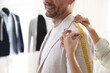 © New Africa - Woman measuring jacket shoulder on man in atelier, closeup