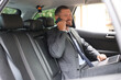 © New Africa - Man with laptop talking on phone in modern car
