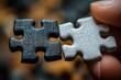 © k - A hand holding black and white puzzle pieces symbolizing choice and difficulty in connection and teamwork