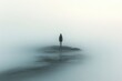 © zong - lonely man walking on the beach looking at the calm sea in a misty landscape with sand and waves