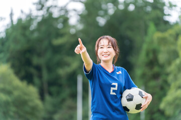 Poster - サッカーボールを持ちながら笑顔でサッカーするファン・サポーターの日本人女性
