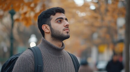 Young caucasian male admiring autumn scenery in park