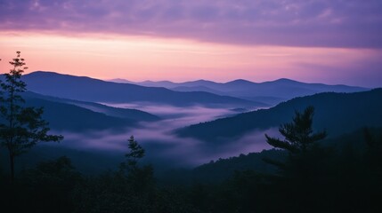 Wall Mural - Majestic mountain landscape at sunset with misty valleys and purple sky