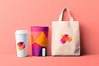© Ade - Colorful branding mockup tote bag, cup, sleeve, and USB drive against pink background; ideal for marketing