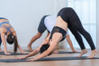 © ultramansk - A peaceful yoga class in a minimal studio where participants perform tree pose with assistance, symbolizing balance, focus, and holistic well-being.