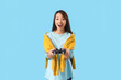 © Pixel-Shot - Happy young Asian woman playing video game on blue background