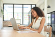 © Prathankarnpap - Confident businesswoman working on her laptop in a bright, modern office space