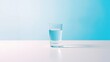 © kavalin - A glass of water, half-full, sits on a white surface against a blue background, a simple, minimalist scene.