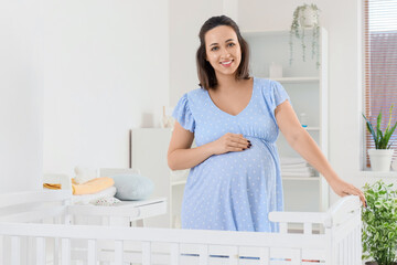 Canvas Print - Young pregnant woman near baby crib in children's bedroom