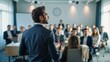 © VistaVisions - Confident businessman giving a presentation in front of crowd in meeting conference seminar room. Leadership authority teamwork in business concept