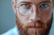 © Harsha - Close up portrait of attractive bearded banker with glasses on grey background