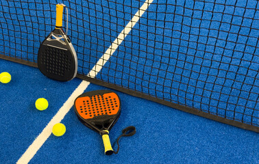 Poster - padel racket on a padel blue court with a ball