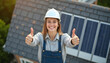 © PTD - smiling woman in hard hat gives thumbs up near solar panels on roof