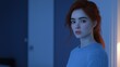 © Lifestyle Images - A woman with red hair is standing in a room with a blue wall