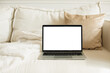 © RooM The Agency - Close-up of an open laptop with a blank screen on a sofa in a stylish living room