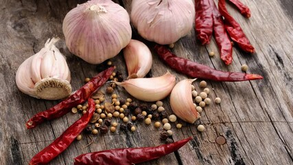 Wall Mural - Garlic, dried chilli and pepper on a wooden table.