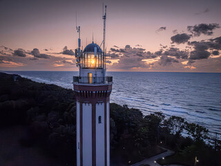 Wall Mural - Light beam from lighthouse by Baltic Sea at dusk