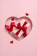 Wall Mural - Gift wrapped with red ribbon in heart shaped cutout for Valentine's Day