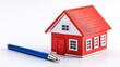© Manon - A vibrant red model house sits beside a blue pen, symbolizing homeownership and real estate.