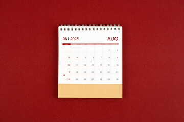 Wall Mural - August 2025 desk calendar on red leather.