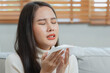 © Pormezz - Sick day at home. Asian woman has sneezing and common cold.