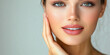 © AndyGordon - A smiling woman gently touching her face, showing clear skin.