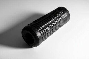 Wall Mural - a close-up view of a sleek black cylindrical object featuring textured grooves. this design emphasiz